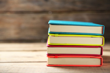 Colorful notebooks on old wooden table