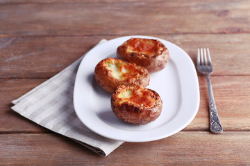 Baked potatoes on pate on wooden table