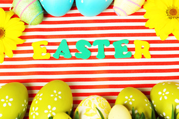 Easter eggs and grass on colorful paper background