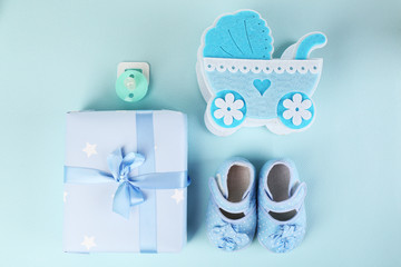 Baby shoes with baby equipment on blue background