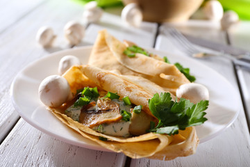 Pancakes with creamy mushrooms and greens in plate