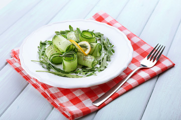 Plate of green salad with cucumber, arugula and rosemary