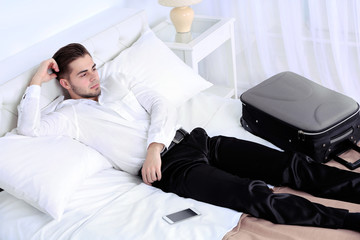 Fototapeta premium Tired man resting on bed in room