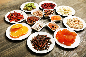 Different products on saucers on wooden table, closeup