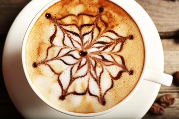 Cup of latte art coffee with grains, closeup