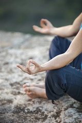 Fototapeta na wymiar Close up of female hand zen gesturing. Girl sits in asana position. 