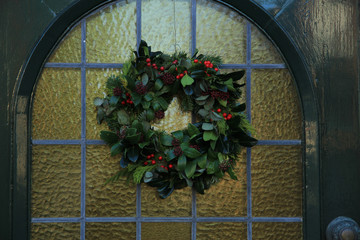 Fototapeta na wymiar Classic christmas wreath with decorations on a door