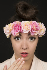 Teen beauty wearing a floral crown with a surprised expression