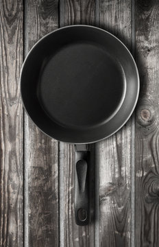 Empty black frying pan on dark wooden table