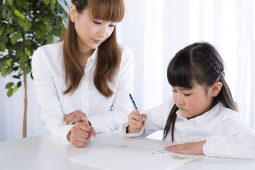 母親に勉強を教わる女の子