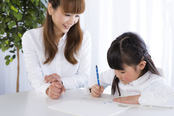母親に勉強を教えてもらう女の子