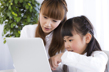 パソコンをしている女の子と母親