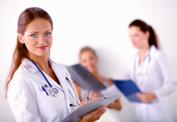 Fototapeta premium Smiling female doctor with a folder in uniform standing at