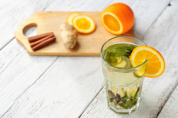 Herbal tea with orange and ginger in glass