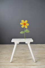 Small white wooden chair with flower  standing on the floor