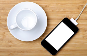 An empty coffee cup and rechargeable smartphone