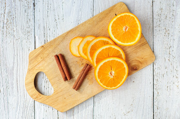 Orange and cinnamon sticks on board