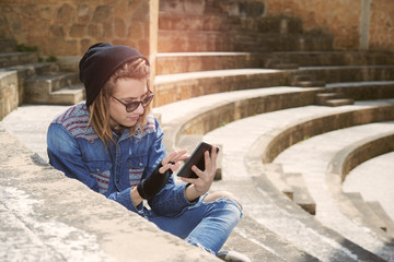 guy sitting on a staircase with tablet warm filter applied