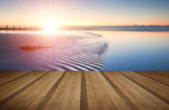 Beautiful low tide beach vibrant sunrise with wooden planks floo