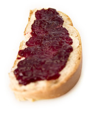 Weizenbrotscheibe (Hefezopf) mit Kirschmarmelade bestrichen