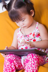Little asian girl using digital tablet, child finger point at co