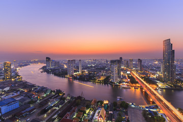 Naklejka premium Rzeka w Bangkoku z wysokim biurowcem w porze nocnej