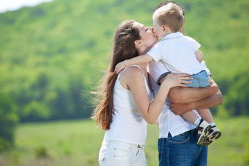 Fototapeta premium Family playing with son in the flowers field