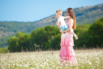 Woman are playing with son in flowers field