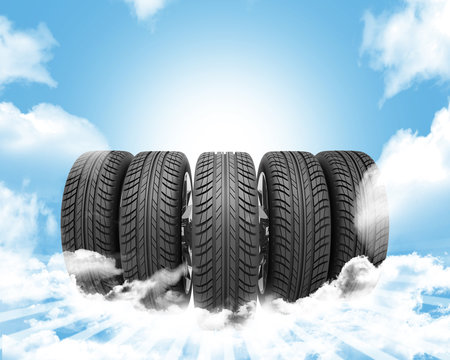 Wedge of new car wheels. Background is sky with clouds and