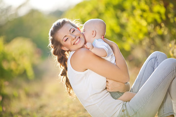 Happy mother with her baby in nature