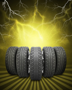Wedge of new car wheels. Yellow background with lightning and