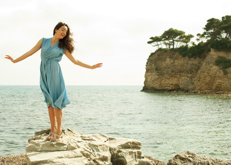 Young happy woman posing near sea