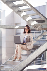 Young successful businesswoman sitting on the stairs