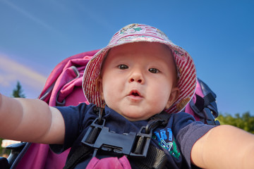 Baby in the park taking his first selfie with an amazed and exci