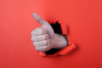 Make a thumb up sign by use his hands through hole on the red pa