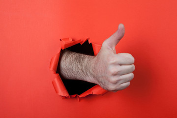 Make a thumb up sign by use his hands through hole on the red pa