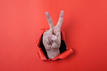 Make a victory sign by use his hands through hole on the red pap