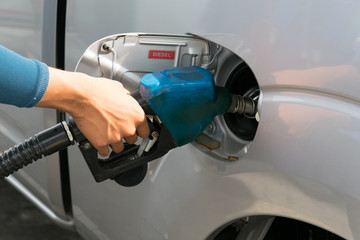 Men hold Fuel nozzle to add fuel in car at gas station