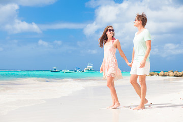 picture of happy couple in sunglasses walking on the beach