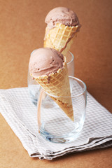 couple of chocolate flavor ice cream cones in a glass on matte b