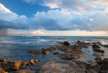 Fototapeta na wymiar Low clouds above the stony shore of the sea. Seascape