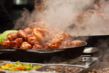 Meat is fried on a big frying pan at street fair