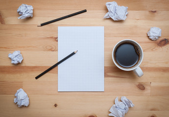 Blank notepad with pencil and coffee on wooden desk