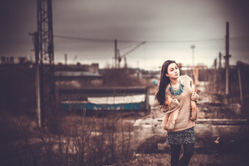 Long hair brunette girl outdoor with old industrial view behind,