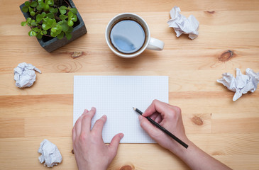 Blank notepad with pencil and coffee on wooden desk