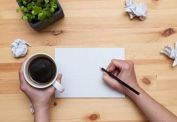 Blank notepad with pencil and coffee on wooden desk