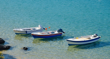 Obraz premium Three moored boats at the sea shore