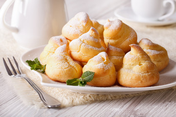profiteroles topped with powdered sugar, horizontal