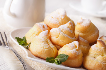 Profiteroles with powdered sugar close-up, horizontal