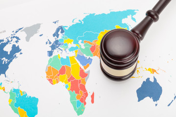Wooden judge's gavel and over world map